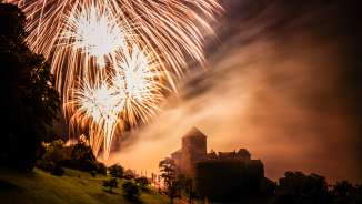Il castello di Vaduz nel Liechtenstein di notte con grandi fuochi d'artificio nel cielo - scatto d'atmosfera con luce e nebbia