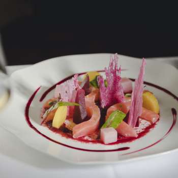 Primo piano di un piatto gourmet con ingredienti freschi, colori vivaci e presentazione creativa