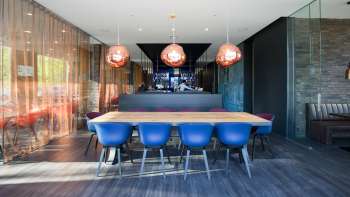 Ristorante moderno con interni eleganti, sedie blu di design ed elegante bar nell'hotel b_smart