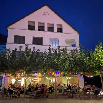 Atmosfera serale del pub St. Martins con terrazza illuminata e luci fiabesche colorate.