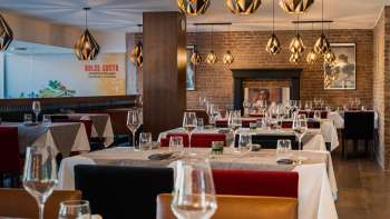 Ristorante elegante con arredi in stile, tovaglie bianche e camino per un'atmosfera accogliente