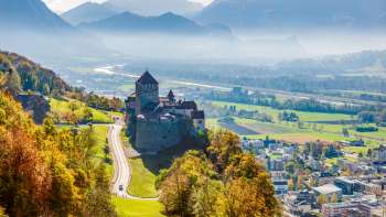 Castello di Vaduz con vista sulla valle del Reno e sul paesaggio montano.