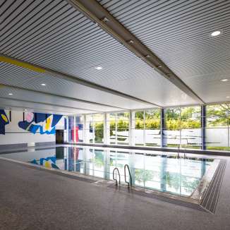 Moderna piscina coperta Resch a Schaan con opere d'arte, grandi finestre e piscina nel Liechtenstein