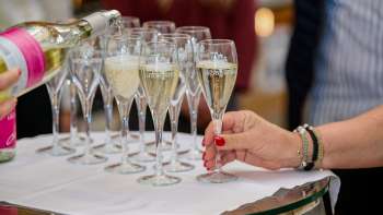 Diversi bicchieri di champagne vengono riempiti su un panno bianco.