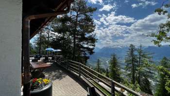 "Terrazza soleggiata con vista panoramica sulla valle del Reno nelle giornate limpide e accoglienti posti a sedere in stile alpino nella Berggasthaus Matu". "Terrazza soleggiata con vista panoramica sulla valle del Reno nelle giornate limpide e accoglienti posti a sedere in stile alpino nella Berggasthaus Matu".