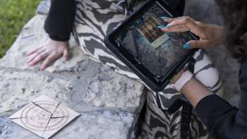 Il giocatore usa l'iPad per risolvere i rompicapo nella sala dell'avventura all'aperto.