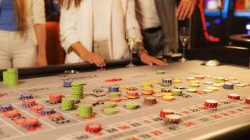 Ospiti al tavolo da gioco che piazzano le loro fiches nel Casinò Admiral Triesen, circondati da un'emozionante atmosfera da casinò.