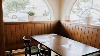 Invitante sala da pranzo con finestre luminose e arredi rustici in legno