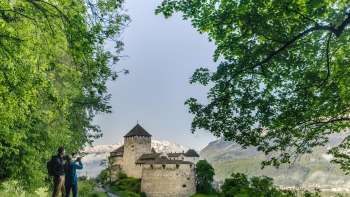 Due persone ammirano il panorama sul castello di Vaduz dal sentiero