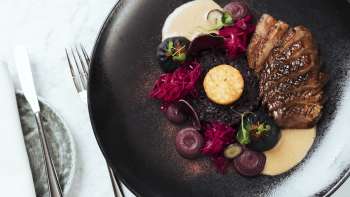 Cibo preparato con stile su un piatto nero nel Capitolo 2