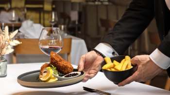 Servito con carne impanata e patatine fritte in una presentazione moderna nel ristorante Alpspitz.