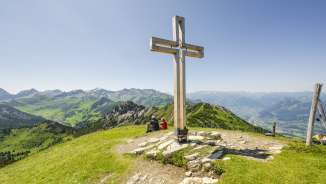Croce di vetta sul monte Schönberg con montagne e vista sulla valle del Reno sullo sfondo