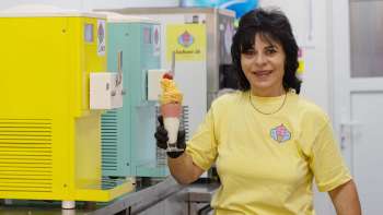 Una simpatica gelataia tiene in mano un gelato nel bar dei gelati Schaan