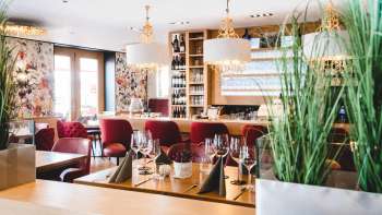 L'interno del PUR Restaurant & Bar è caratterizzato da eleganti sedie rosse imbottite e tavoli apparecchiati con stile.