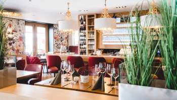 L'interno del PUR Restaurant & Bar è caratterizzato da eleganti sedie rosse imbottite e tavoli apparecchiati con stile. L'interno del PUR Restaurant & Bar è caratterizzato da eleganti sedie rosse imbottite e tavoli apparecchiati con stile.