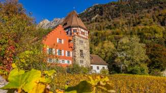 La Casa Rossa di Vaduz, nel Liechtenstein, immersa in un colorato paesaggio autunnale e in vigneti ai piedi delle montagne.