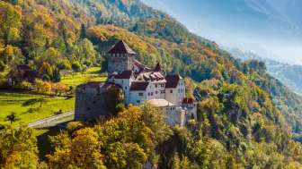 Il castello di Vaduz in autunno Il castello di Vaduz su una collina boscosa in un paesaggio autunnale nel Liechtenstein