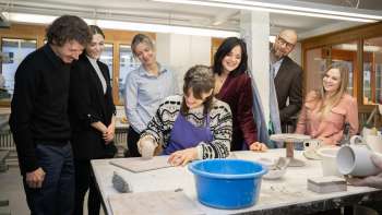 Un gruppo di visitatori interessati assiste alla modellazione di un vasaio: un'esperienza creativa in un'atmosfera accogliente presso il laboratorio di ceramica Schädler di Nendeln.