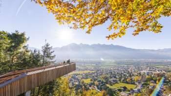 Piattaforma panoramica sul sentiero avventura nel bosco a Vaduz con vista sulla valle soleggiata Piattaforma panoramica sul sentiero avventura nel bosco a Vaduz con vista sulla valle soleggiata