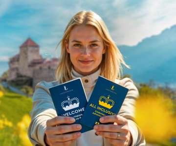Donna presenta il «Pass attrazioni BENVENUTO» e «Pass attrazioni TUTTO INCLUSO» davanti al Castello di Vaduz