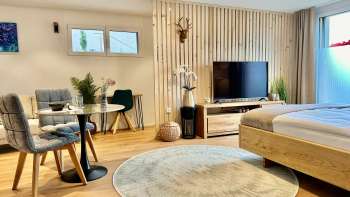 Monolocale elegantemente arredato con letto king-size, TV a schermo piatto e tavolo con due sedie