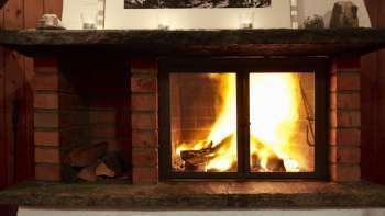 Caldo camino con legna ardente e luce d'atmosfera