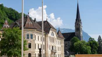  Vista attraverso un arco a tutto sesto del quartiere governativo di Vaduz con il palazzo del Parlamento e la Cattedrale di San Florin.