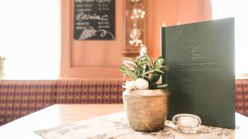 Primo piano di una tavola imbandita con carte da menu, fiori e decorazioni rustiche