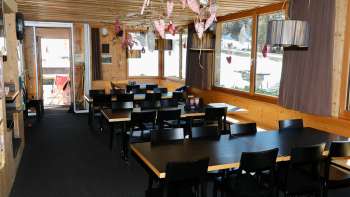 Accogliente sala da pranzo con pareti in legno, ambiente rustico e decorazioni amorevoli nel ristorante Schneeflucht Accogliente sala da pranzo con pareti in legno, ambiente rustico e decorazioni amorevoli nel ristorante Schneeflucht