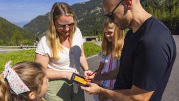 La famiglia inserisce i punti del minigolf in una scorecard