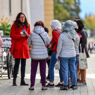 Gruppo di turisti con guida della città in cappotto rosso durante una visita guidata nel centro di Vaduz, in Liechtenstein