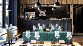 Accogliente sala da pranzo con disposizione rilassata dei posti a sedere, arredi moderni e pareti dal design creativo