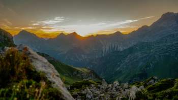 Tramonto sulla cresta - Il sole si abbassa dietro le cime delle montagne e bagna il panorama alpino con i caldi colori della sera.