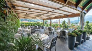 Elegante terrazza ristorante con tavoli coperti e vista panoramica sulle Alpi del Liechtenstein.