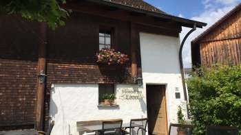 Locanda rustica con facciata in legno e finestre adornate di fiori