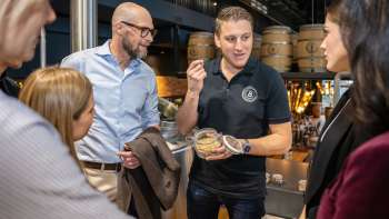 Un dipendente spiega gli ingredienti della produzione di birra a un gruppo di ospiti interessati durante una visita al birrificio.