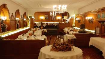 Sala allungata con tavoli imbanditi a festa, decorazioni eleganti e illuminazione calda Sala allungata con tavoli imbanditi a festa, decorazioni eleganti e illuminazione calda