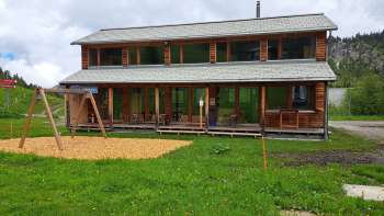 Esterno del Malbipark-Bistro con parco giochi e prato in primo piano