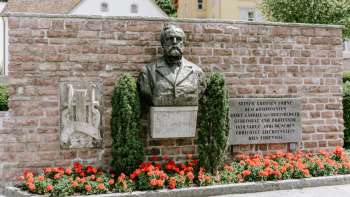 Il monumento Rheinberger a Vaduz con i fiori rossi sotto di esso