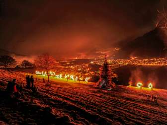 Gli spettatori assistono allo spettacolo notturno con vista sulla valle del Reno illuminata.