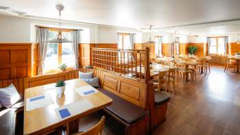 Luminosa sala da pranzo in stile tradizionale con pannelli in legno nel ristorante Rössle.