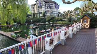 Barche telecomandate nel bacino d'acqua dell'Europa-Park, circondato da case a graticcio e alberi primaverili