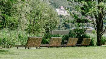 Prato con lettini in legno con vista sul castello di Vaduz