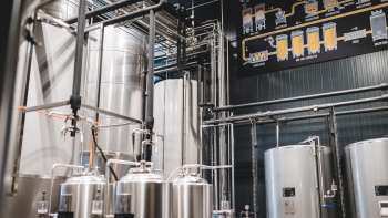 Vista della sala tecnica del birrificio con il suo complesso sistema di tubature e i moderni serbatoi in acciaio inox.