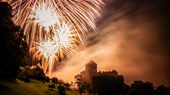 Il castello di Vaduz nel Liechtenstein di notte con grandi fuochi d'artificio nel cielo - scatto d'atmosfera con luce e nebbia