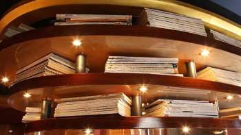 Scaffale in legno con libri illuminati come rivestimento del soffitto