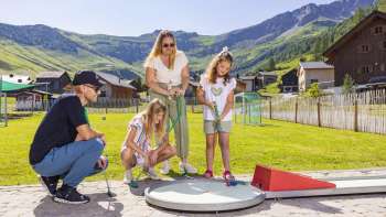 Famiglia che gioca a minigolf sul minigolf alpino a Malbun