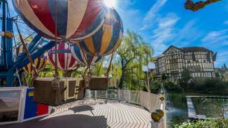 Primo piano della giostra a tema Liechtenstein all'Europa-Park: palloncini colorati sullo sfondo di case a graticcio sotto il sole.