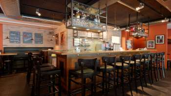 Elegante foto dell'interno del bar del Nuovo Castello di Vaduz, con una fornita bottigliera e un'accogliente area salotto.