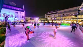 Persone che pattinano sul ghiaccio sulla pista illuminata di «Vaduz on Ice», nel centro di Vaduz, di sera
